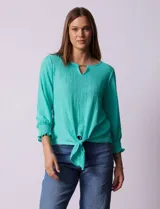 Blusa verde agua de tejido texturado marca Ruby Rd, con cuello a la base, escote en V con aplique metálico, mangas tres cuartos con puños elásticos y terminación de ruedo con nudo.