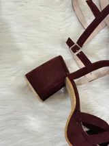 Sandalias de plataforma color vino con tiras cruzadas y tobillera con hebilla.