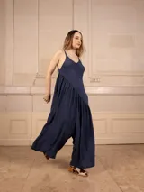 Mono largo de tirantes símil jean, con corte asimétrico y bolsillos laterales.