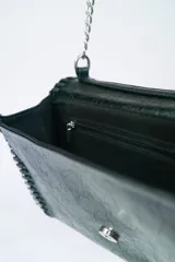 Bandolera negra con cadena plateada y pespuntes en los bordes.