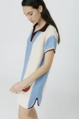 Vestido tipo polo tejido en jersey liviano de algodón y acrílico, con rayas horizontales en color crudo y marrón. Presenta bordado XL de un ají rojo y terminaciones acanaladas en las mangas.