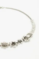 Cinturón plateado de metal con cadena de eslabones y apliques de flores.