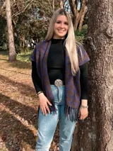 Ruana de paño con diseño a cuadros en tonos azul y marrón, con flecos en el borde inferior.