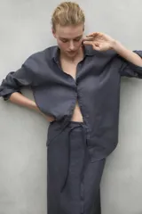 Camisa blanca de lino con corte clásico, cuello camisero y mangas largas.