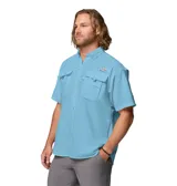 Camisa celeste de manga corta Columbia modelo Bahama II, confeccionada en tejido de secado rápido con protección solar UPF 50, ventilación en la espalda, soporte para caña de pescar y múltiples bolsillos en el pecho.