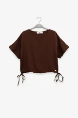 Top marrón de lino y tencel con mangas cortas y lazo ajustable en el ruedo.