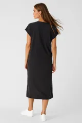 Vestido midi negro de algodón con estampado frontal de calavera y texto en amarillo y naranja.