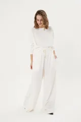 Pantalón palazzo color crudo, de morley térmico suavizado, con bolsillos laterales, cintura elastizada y cordón ajustable.