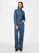 Mono largo de denim azul con corte recto, cuello camisero, cierre frontal con botones a presión y cremallera, bolsillos delanteros y traseros.