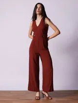 Mono enterito color ladrillo, marca June & Hudson, de crepe con escote en V, sin mangas, con detalle de botones en la cintura y cierre invisible en la espalda.