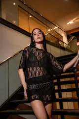 Remerón oversize de encaje negro con cuello redondo y mangas cortas.