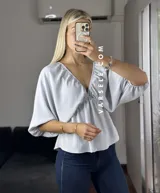 Blusa verde agua con escote en V, mangas cortas abullonadas y tiritas para atar.