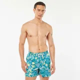Short de baño azul con estampado de hojas y flores en tonos verde, amarillo y gris.