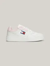 Zapatillas Tommy Jeans Essential de cuero blanco con detalles en rosa en el talón y en la lengüeta. Presentan el logo de la marca en el lateral y suela de goma. Inspiradas en los modelos de baloncesto, cuentan con elementos distintivos tonales y un detalle de ventilación en la punta que les aporta un aire deportivo retro.