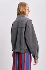 Campera de jean gris oscuro con cuello clásico, cierre frontal con botones metálicos, bolsillos con solapa en el pecho y corte holgado.