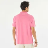 Remera polo de piqué color rosa con cuello clásico y borde blanco.