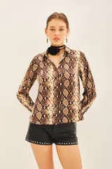 Camisa de manga larga con estampado de reptil, corte masculino y cuello camisero.