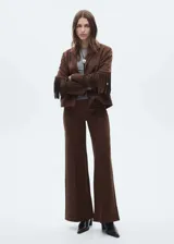 Chaqueta marrón con efecto piel, cuello con solapa, sin cierre, diseño recto y detalle de flecos en mangas y espalda.