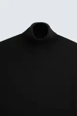 Jersey negro de punto fino con cuello alto y manga larga.