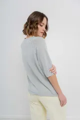Buzo ligero de tejido fino color gris, con calce relajado, mangas 3/4 y escote redondo.