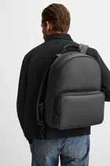 Mochila negra con acabado grabado, compartimento principal con cierre de cremallera, bolsillo interior con cremallera, bolsillo frontal con cremallera, asa de mano, dos asas de hombro ajustables, parte posterior acolchada y banda de sujeción para equipaje.