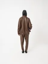 Pantalón negro de cuero sintético con corte slim fit, cintura elástica con cordón ajustable y bolsillos laterales. Acabado vintage.