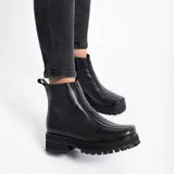 Botas cortas color marrón de cuero vacuno con suela track negra de goma. Presentan cierre lateral con cremallera YKK y puntera cuadrada.