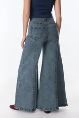 Pantalón de jean celeste con corte acampanado, tiro alto y costuras verticales al frente.