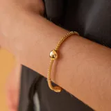 Pulsera de oro amarillo 18k con eslabones tipo malla y esfera central.