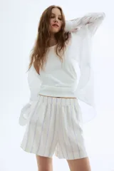 Short blanco con finas rayas verticales celestes, cintura elastizada y corte holgado.