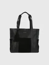 Bolso tipo shopper Hush Puppies de cuero sintético negro con panel frontal de gamuza negra. Tiene doble asa de hombro, bolsillos laterales y adorno de borla colgante.
