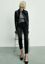 Pantalón de jean negro, tiro alto, corte mom fit, con cinco bolsillos y cierre de cremallera y botón.