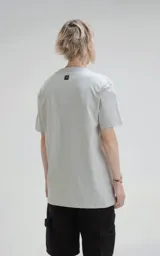 Remera gris de manga corta, cuello redondo y calce regular con recorte en espalda, realizada en algodón premium muy suave al tacto.