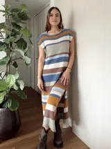 Vestido largo tejido con hilo de algodón en punto jersey rayado, con cuello redondo y mangas cortas. Diseño a rayas horizontales en tonos azul, marrón, beige y blanco. Hecho a mano con máquina de carro y terminaciones en crochet.