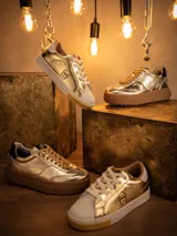 Zapatillas deportivas doradas de cuero con cordones color beige y suela marrón.