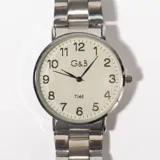 Reloj de pulsera plateado con esfera blanca, números arábigos negros y agujas negras.