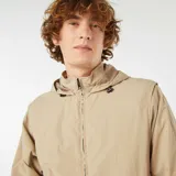 Cortavientos beige con cierre frontal con cremallera, capucha y mangas largas extraíbles.