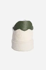 Zapatillas urbanas blancas con detalles en cuero color crema y talón en cuero verde oscuro.
