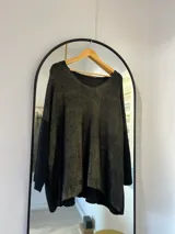 Sweater negro de corte recto con escote en pico y detalle de brillo sublimado.