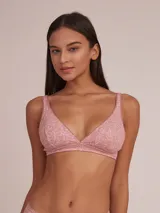 Soutien halter de algodón color rosa con estampado de hojas blancas y detalle de puntilla en el escote.