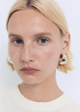 Remera de punto fino color blanco, de manga corta y cuello redondo, corte entallado.