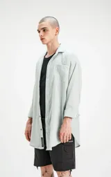 Camisa manga larga verde agua, de calce oversize con bolsillo ojal en delantero y cartera escondida.