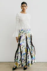 Falda larga con estampado abstracto en tonos pastel y tierra, con volados verticales de tul marrón oscuro que recorren la prenda.