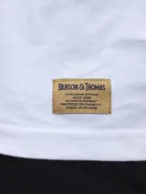 Remera lila de algodón con cuello redondo y estampado vertical con el texto "Benson & Thomas".