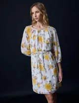 Vestido corto de gasa estampada con flores amarillas, marca Sandra Darren. Tiene escote redondo, mangas 3/4 con puño elastizado y lazo de ajuste en la cintura.