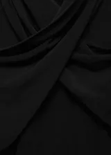 Remera negra de cuello alto cruzado, entallada y de manga larga.