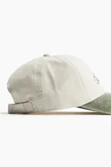 Gorra de béisbol color crema con visera verde, con bordado frontal que dice 'Tribeca Tennis Club'.