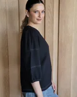 Blusa verde de mangas 3/4 con cuello redondo.