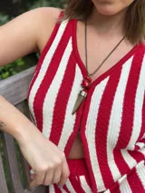 Collar con dije de cuerno de guampa y corales naturales engarzado en alpaca. Tiene tiento sintético color camel con cierre deslizable para regular el largo y usarlo doble.