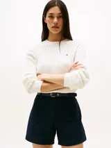 Sweater blanco de punto trenzado fino con cuello redondo y logo de Tommy Hilfiger bordado en el pecho.